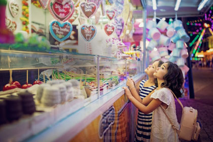 Deux petites filles qui regardent une vitrine de bonbons
