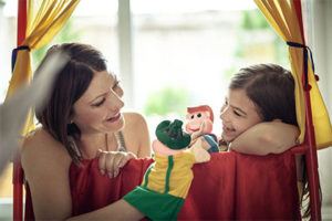 Mère et fille qui jouent avec des marionnettes